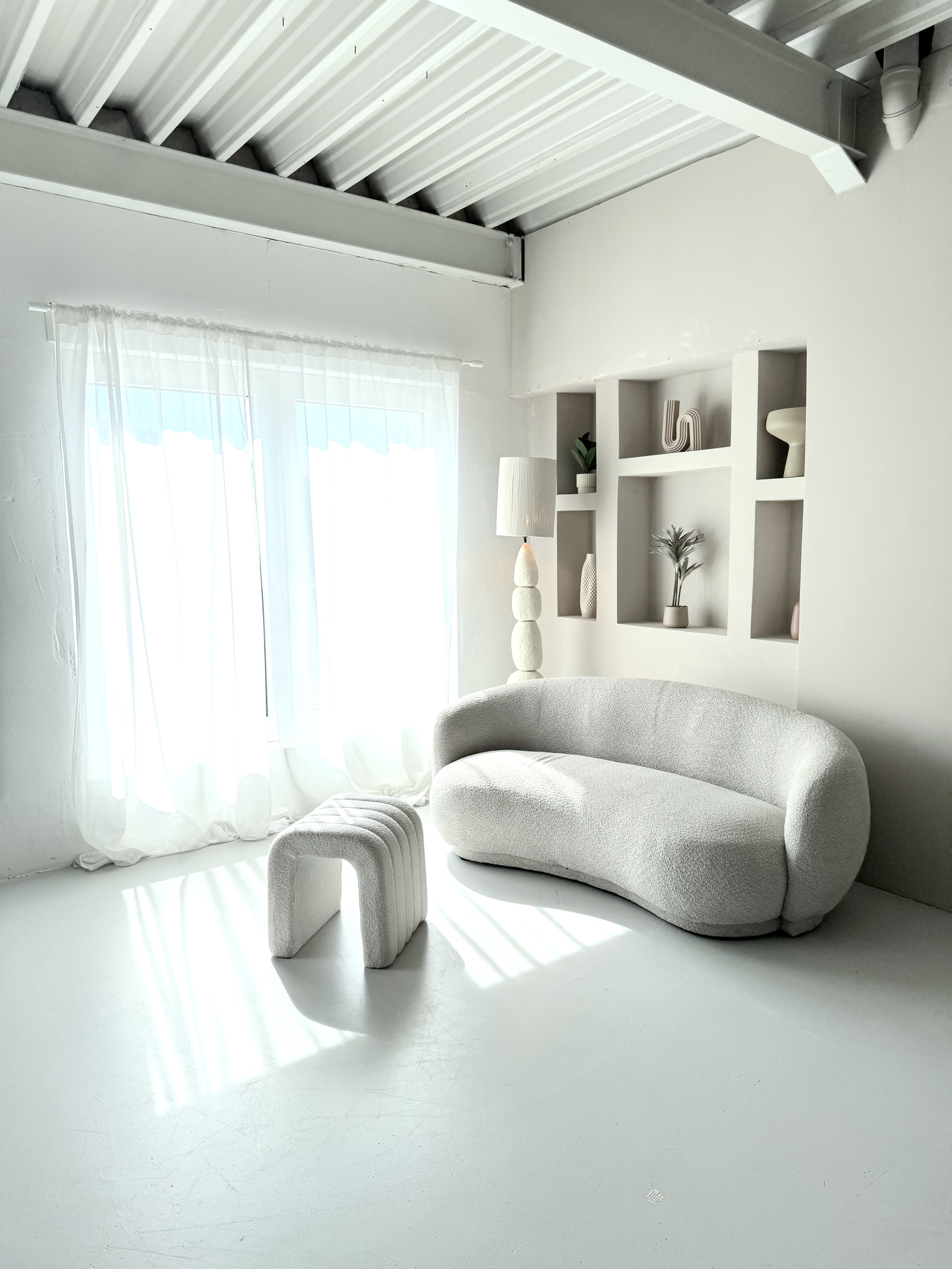 Beige Studiocouch mit hellem Fensterlicht und ruhigem Setdesign